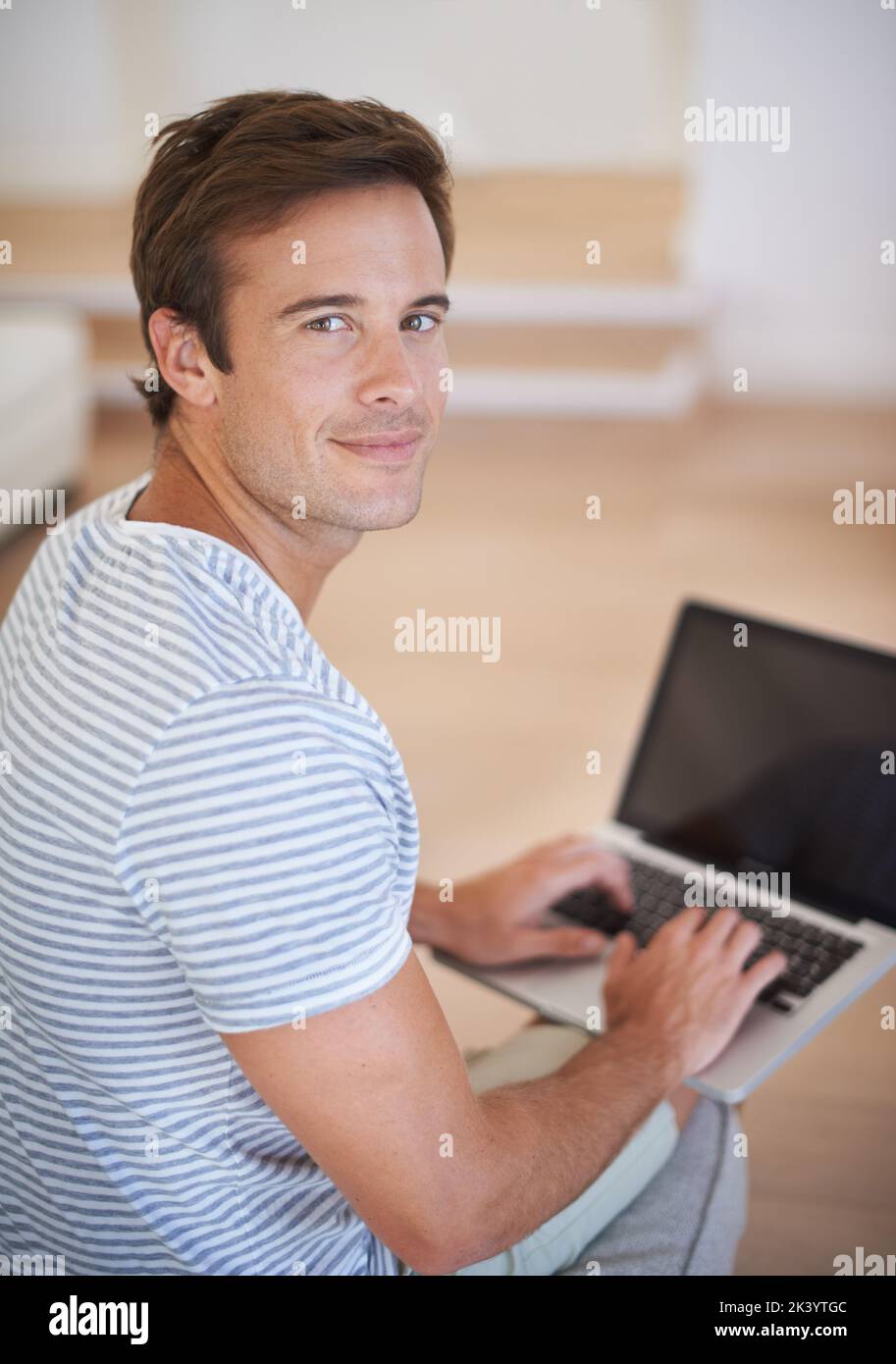 Happy with his internet package. A young man using a laptop and smiling at the camera. Stock Photo