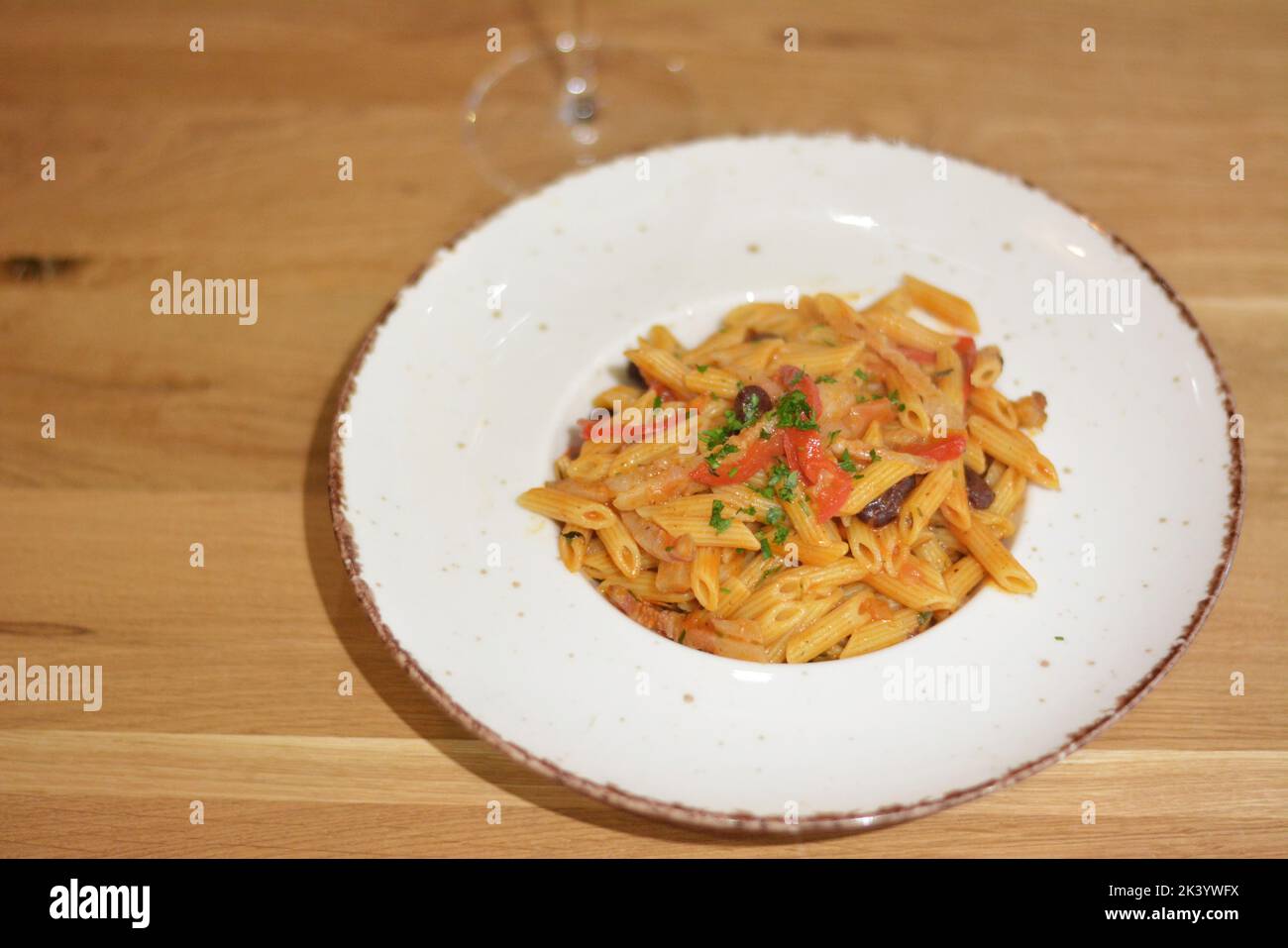 Pasta penne with bacon and beans. Seasoned with tomatoes and parsley