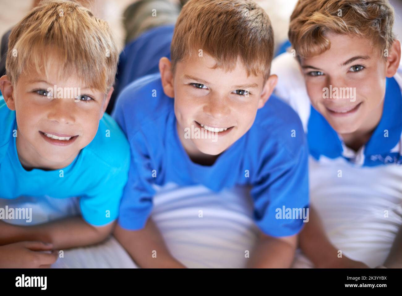 Theyre so alike. Three brothers smiling at the camera happily. Stock Photo