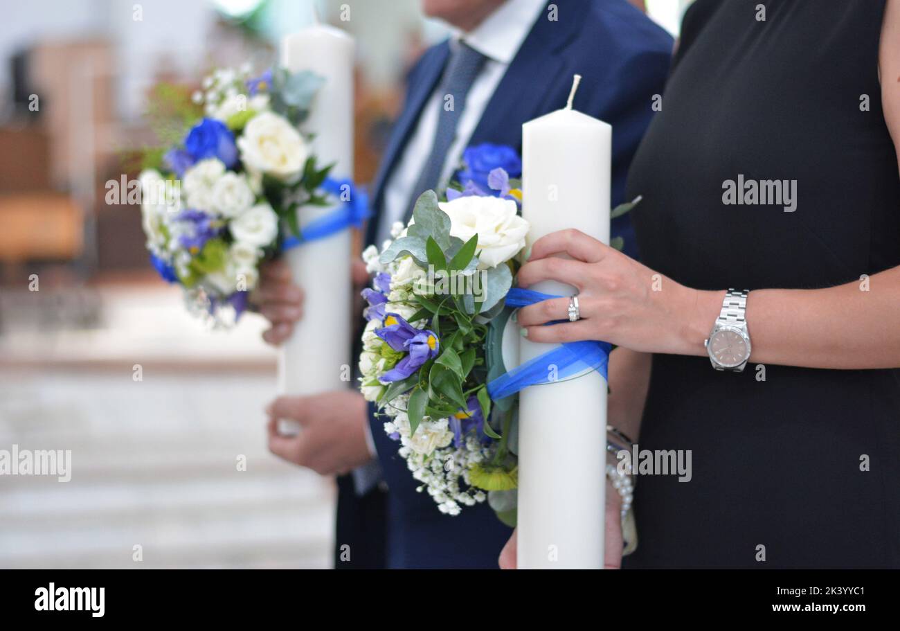 The godparents hold the wedding candles in their hands Stock Photo Alamy