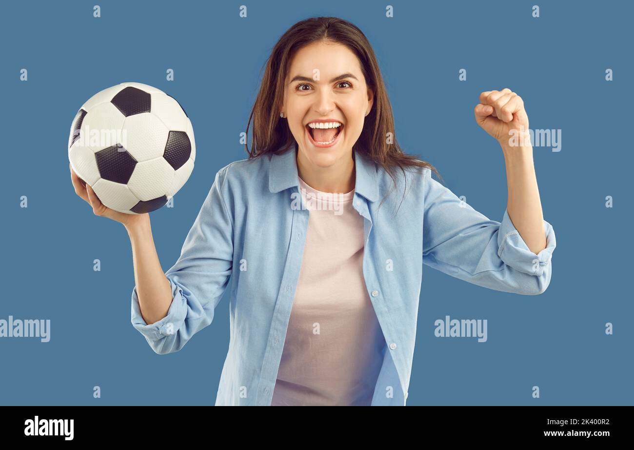 Joyful excited woman with soccer ball in her hand is crazy happy after winning bet. Stock Photo