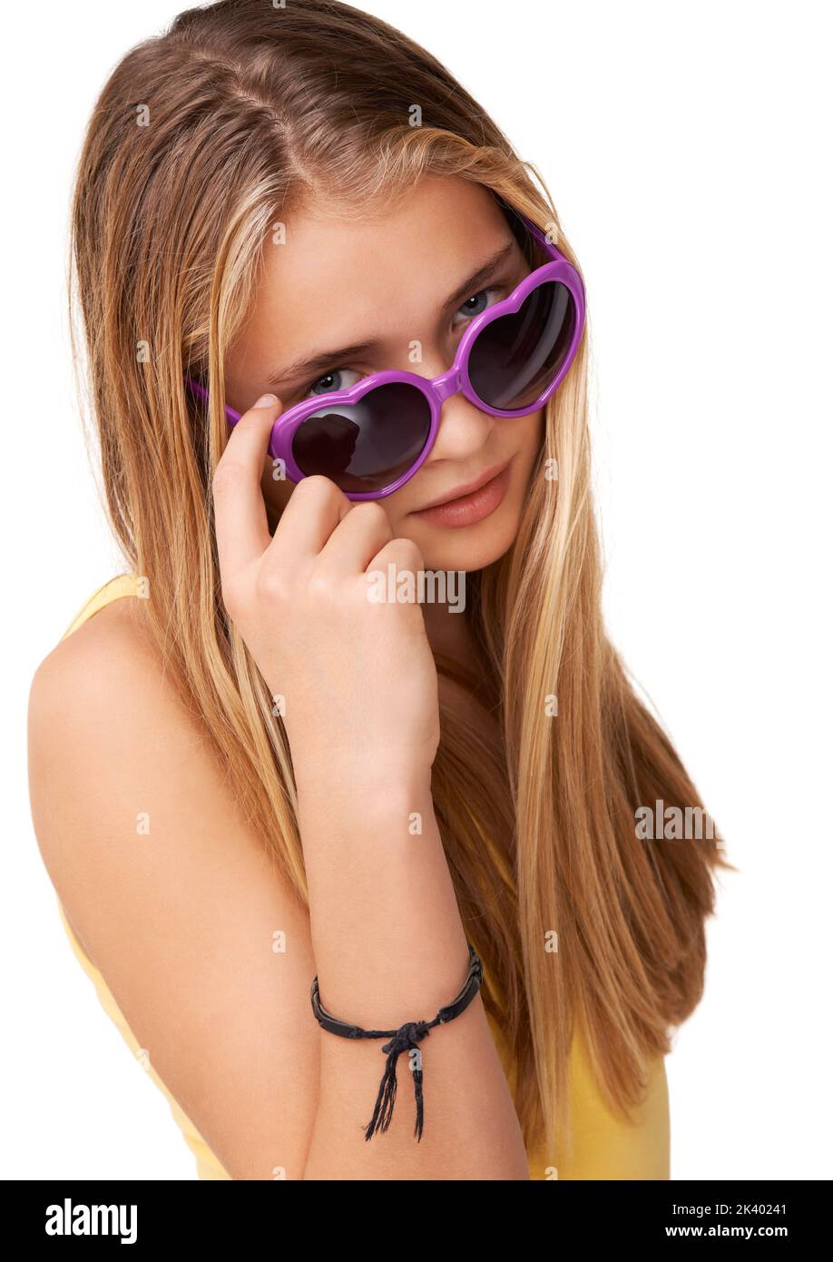 Peering over at you. Portrait of a cute teen girl peering over her heart-shaped glasses. Stock Photo