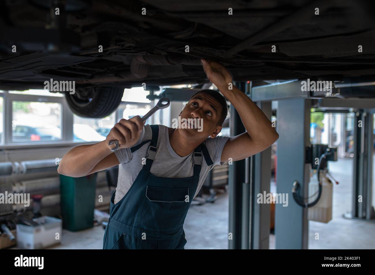 Experienced automotive technician fixing the car undercarriage Stock Photo