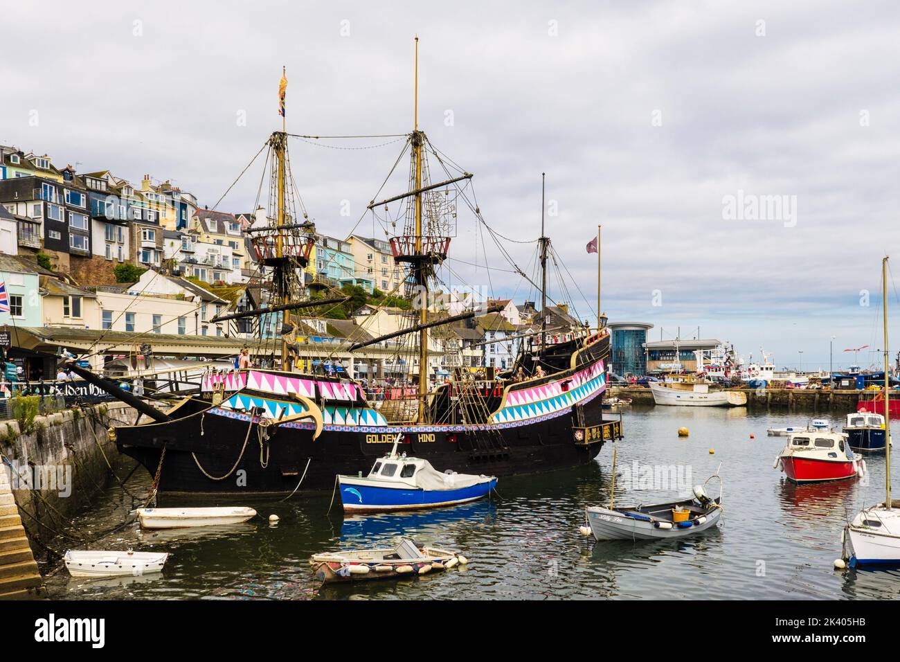 Replica of the Golden Hind galleon with small boats moored in the inner harbour. Brixham, Devon, England, UK, Britain Stock Photo