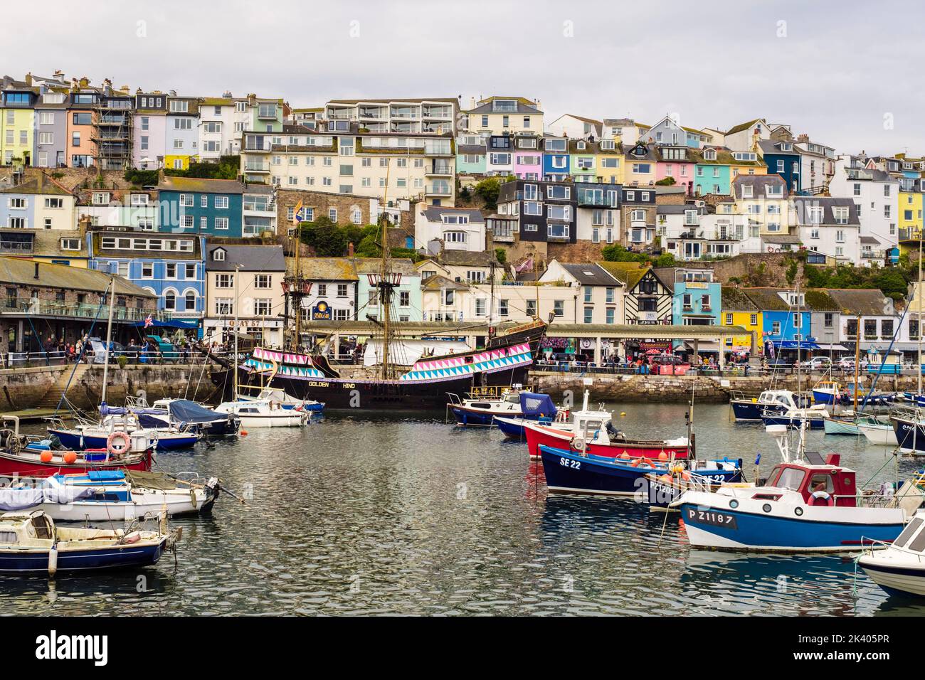 Colourful houses and shops overlooking the inner harbour with small boats moored. Brixham, Devon, England, UK, Britain Stock Photo