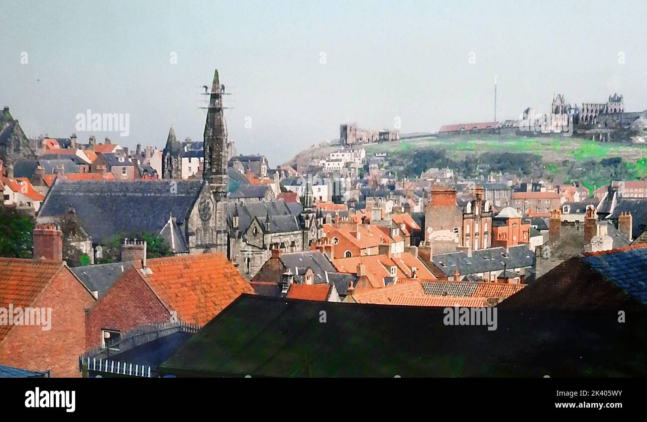 1987STEEPLEJACKS - Replacing an  unstable old  steeple with a shorter fiberglass replacement on the Catholic Church at the foot of Brunswick Street, in Whitby North Yorkshire. This view over the red  pantiled roofs of the town  also shows St Mary's Parish church and the old abbey. Stock Photo