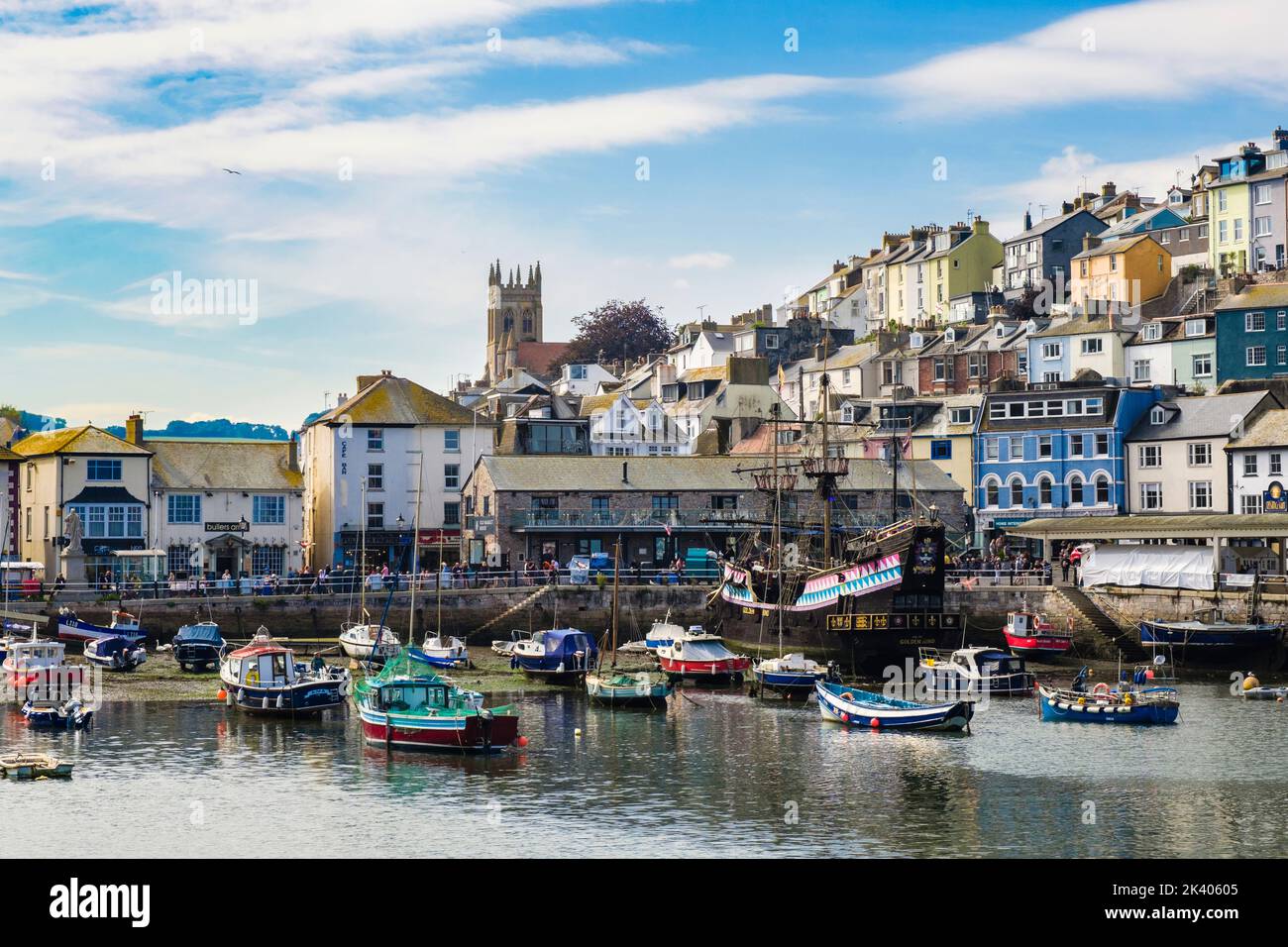 Houses and shops on the harbourfront by the inner harbour with small boats moored in picturesque Brixham, Devon, England, UK, Britain Stock Photo
