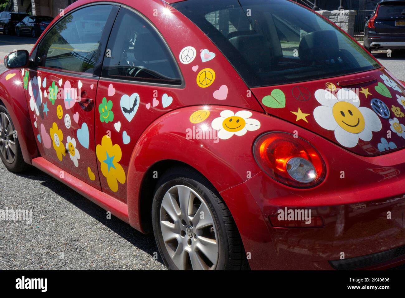 A red 2010 Volkswagen bug covered with stickers reminiscent of the 1960s. In a parking lot in Chappaqua, New York. Stock Photo
