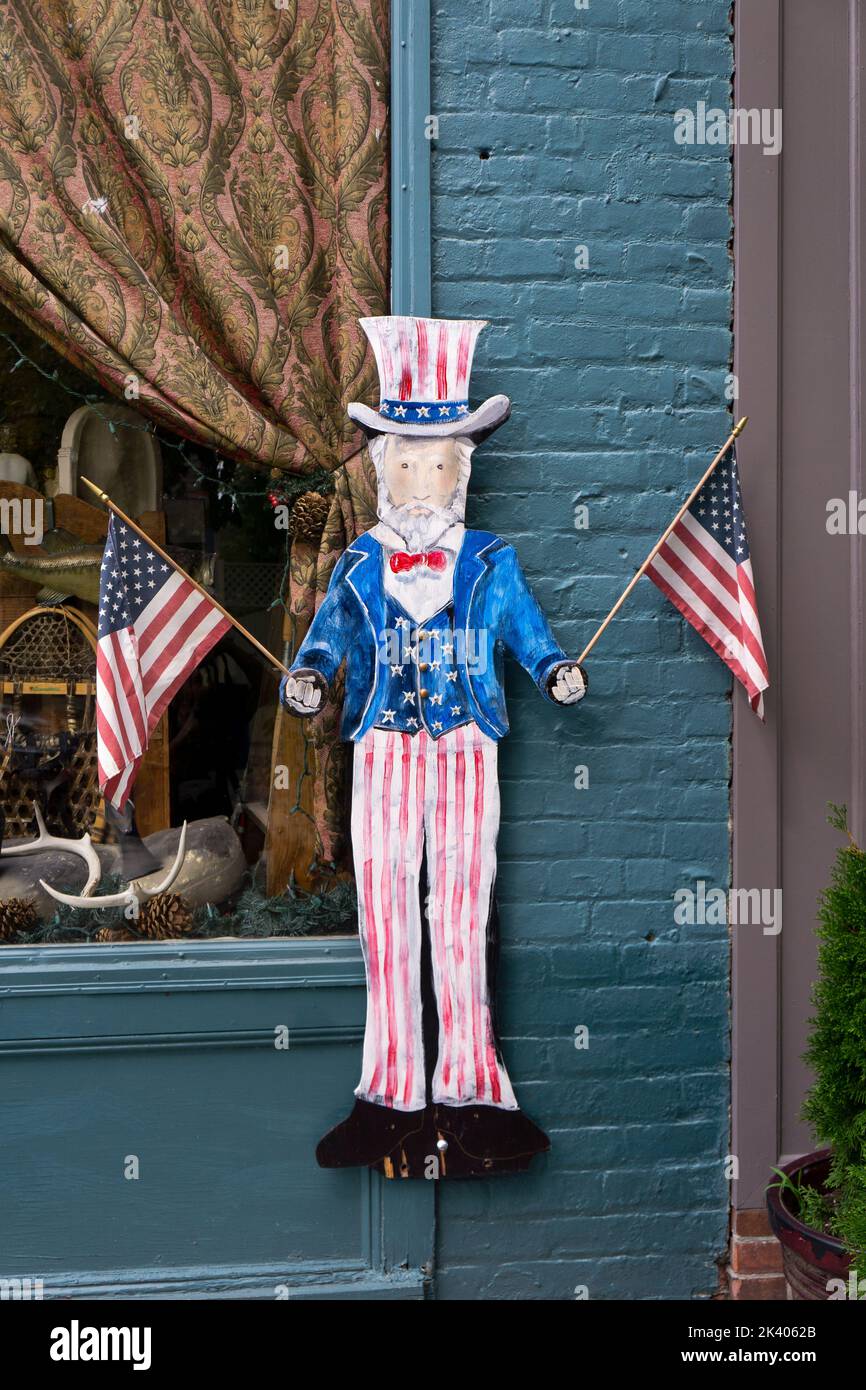 A metal Uncle Sam waving 2 American flags on the outside of ONCE UPON A TIME, an antique store on Main Street in Cold Spring, New York. Stock Photo