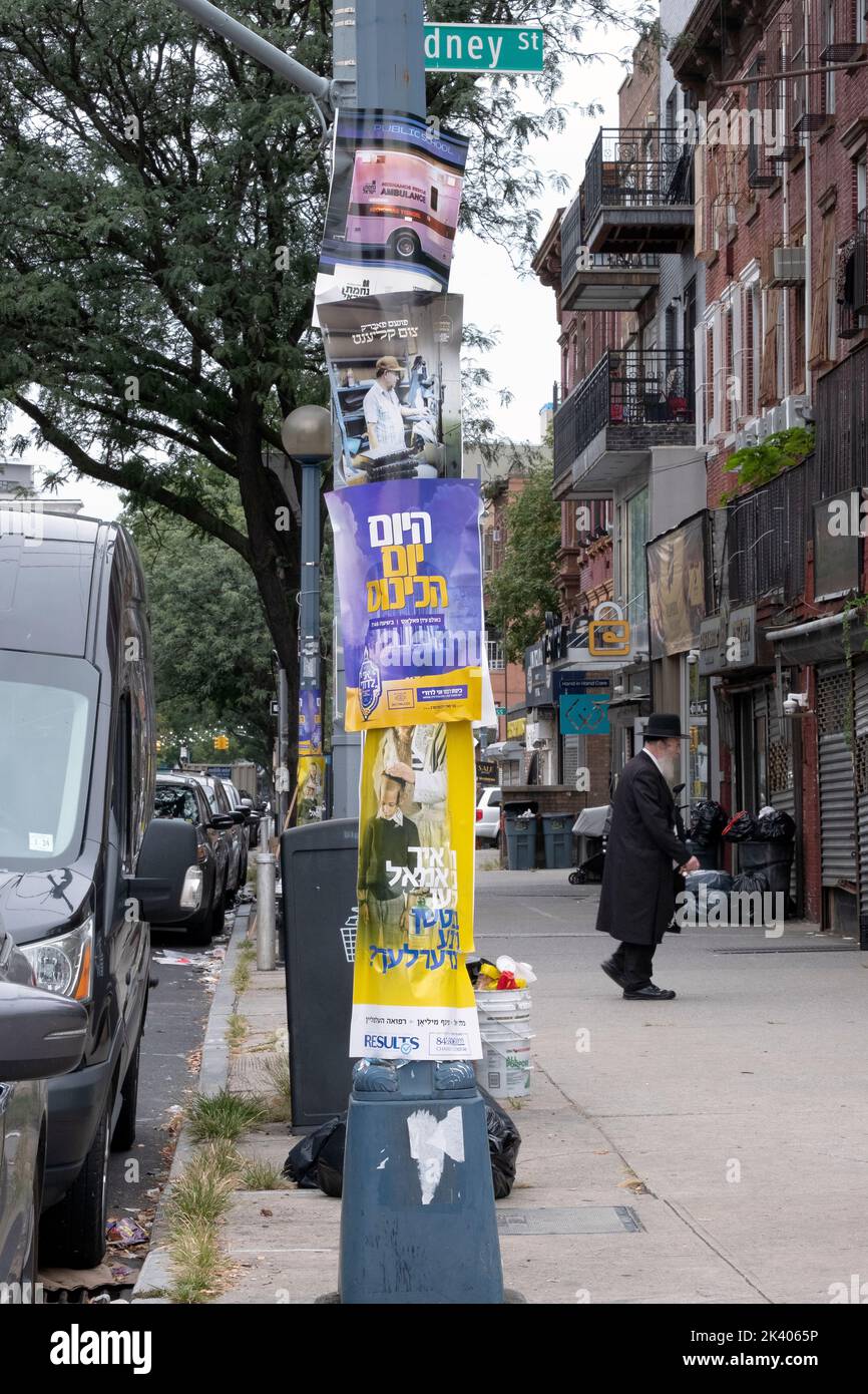 A street scene on Lee Ave. corner of Rodney sSt with posters in Yiddish, english and Hebrew.in Williamsburg, Brooklyn, New York City. Stock Photo