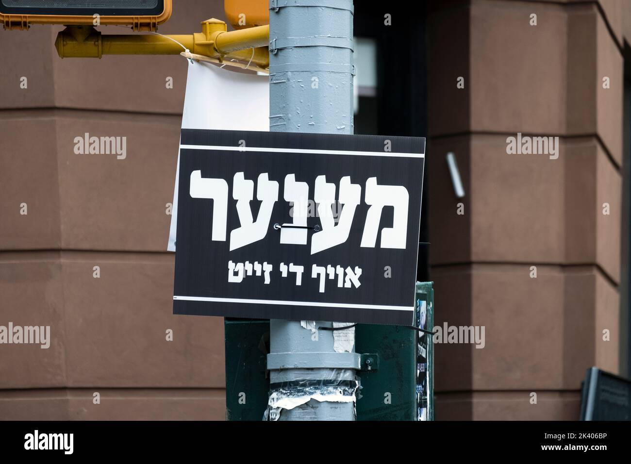A Yiddish sign directing traffic during the busy fall holiday months and pointing men to a particular side of the street. Stock Photo