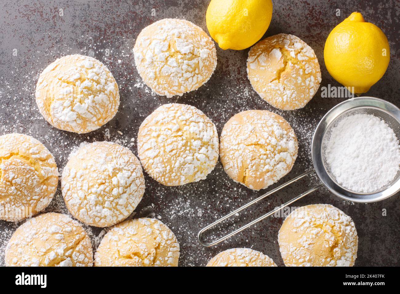 Homemade cracked lemon cookies with powdered sugar and zest close-up on the table. horizontal top view from above Stock Photo