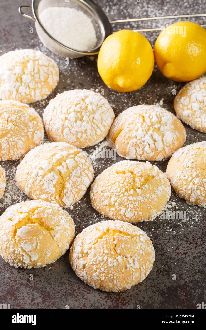 Sweet and sour lemon cookies with powdered sugar and zest close-up on the table. Vertical Stock Photo