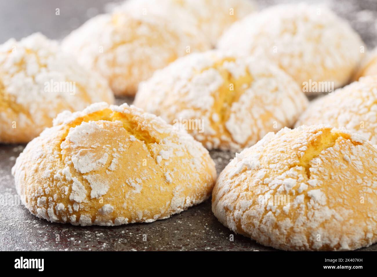Close-up of cracked lemon biscuits sprinkled with powdered sugar close-up on the table. horizontal Stock Photo