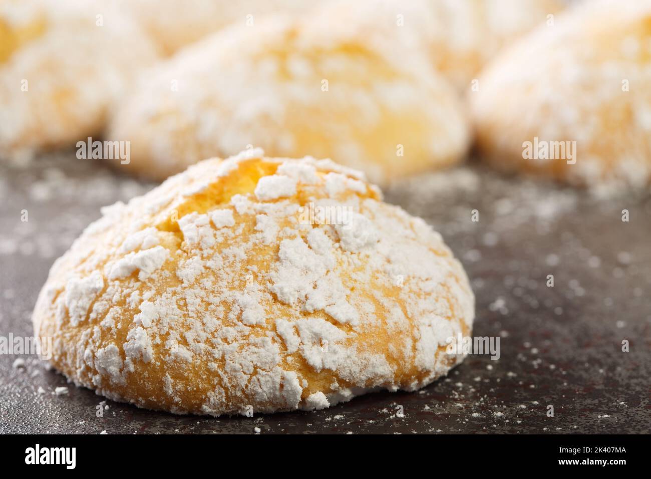 Homemade cracked lemon cookies with powdered sugar and zest close-up on the table. horizontal Stock Photo