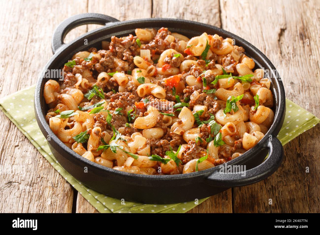 American Hamburger Goulash with Elbow Macaroni closeup in the pan on the wooden table. Horizontal Stock Photo