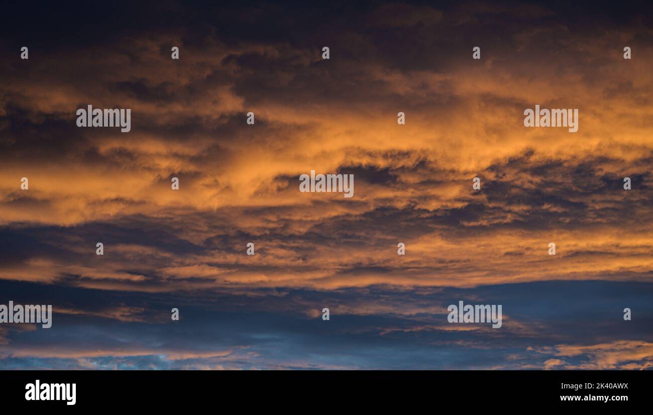 Sunset sky with orange clouds. Nature background. Stock Photo