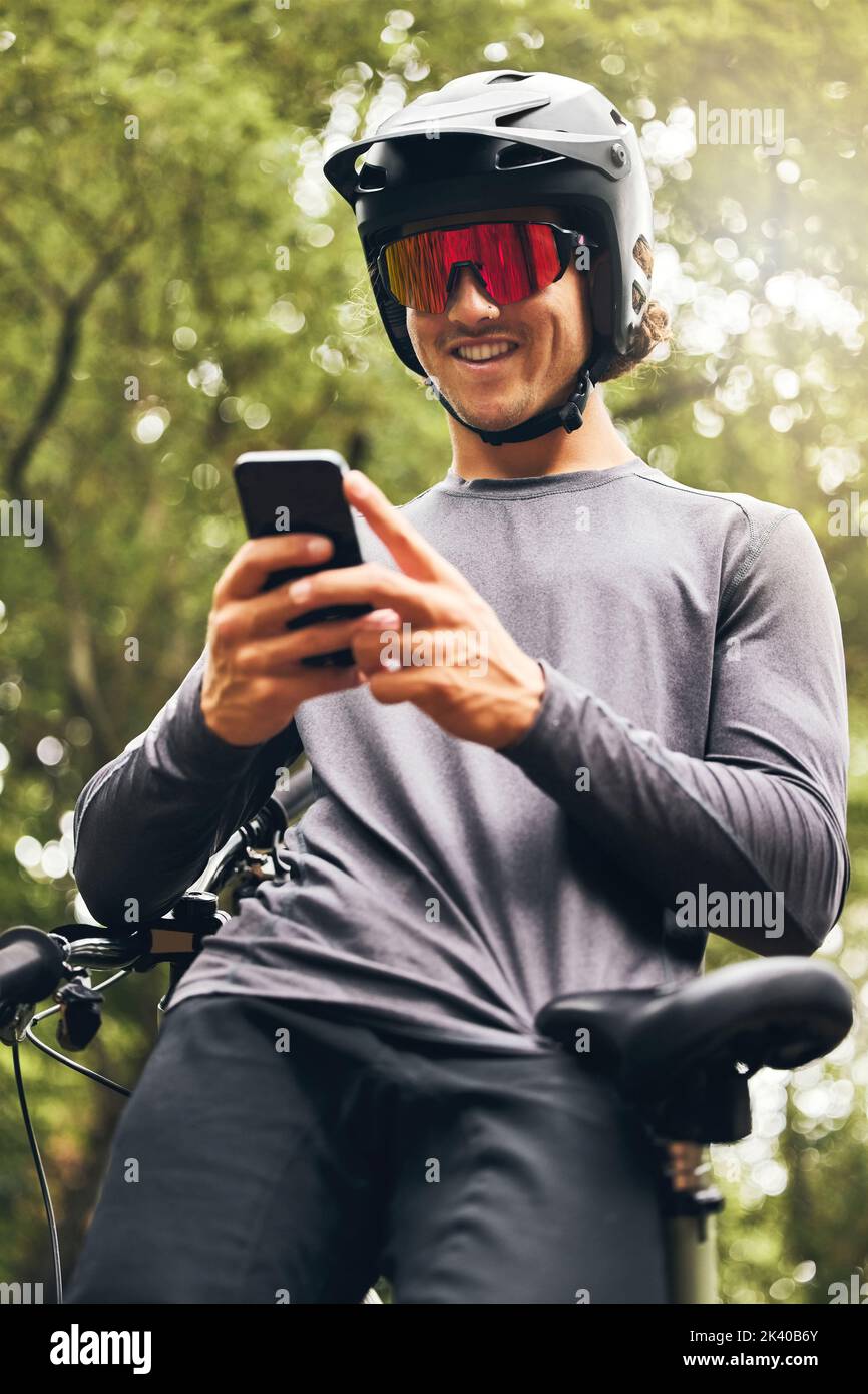 Cyclist, fitness and phone app for gps, health data and location trail in nature forest, countryside and Australian woods. Smile, happy and motivation Stock Photo