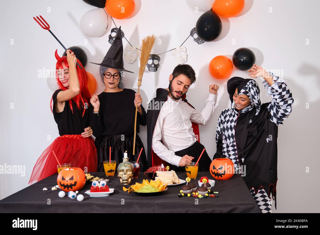 Four people dancing at a costume Halloween party. Stock Photo