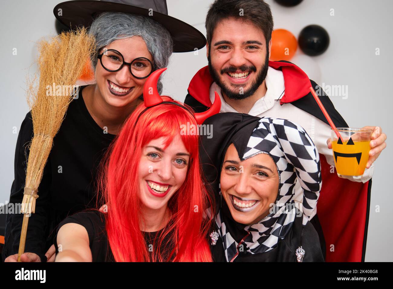 Four people taking a selfie photo at a costume Halloween party. Stock Photo
