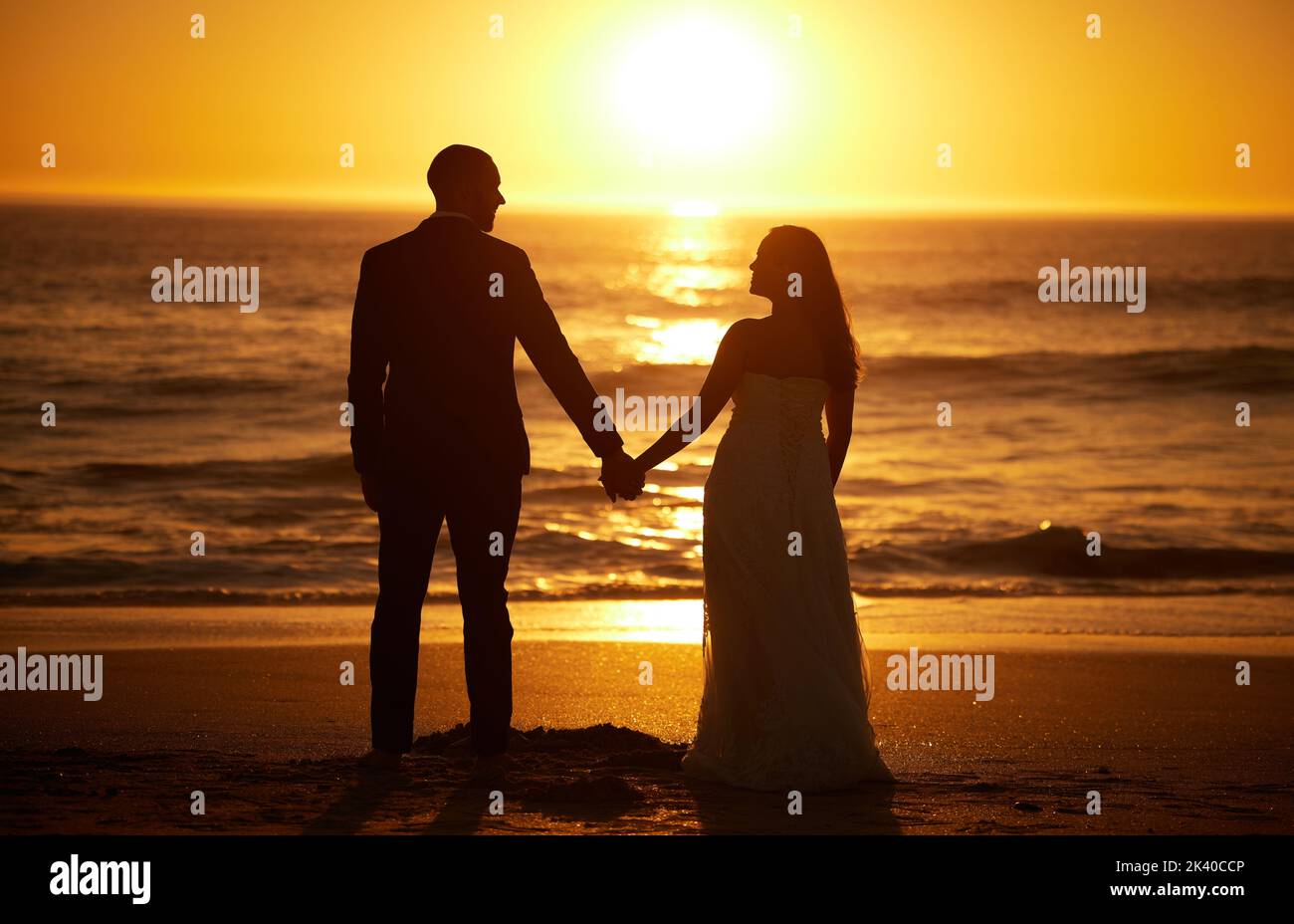 Love, summer and couple at a beach at sunset, silhouette holding hands ...