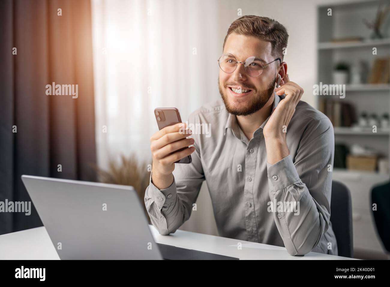 Happy smiling student use earphones for education, handsome man studying remotely from home, online listening course at laptop Stock Photo