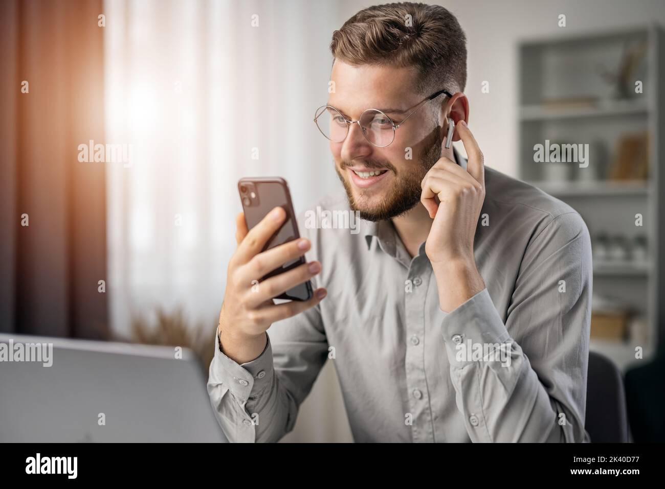 Handsome bearded student listening to online course, happy smiling man use earphones to studying, ebook concept Stock Photo
