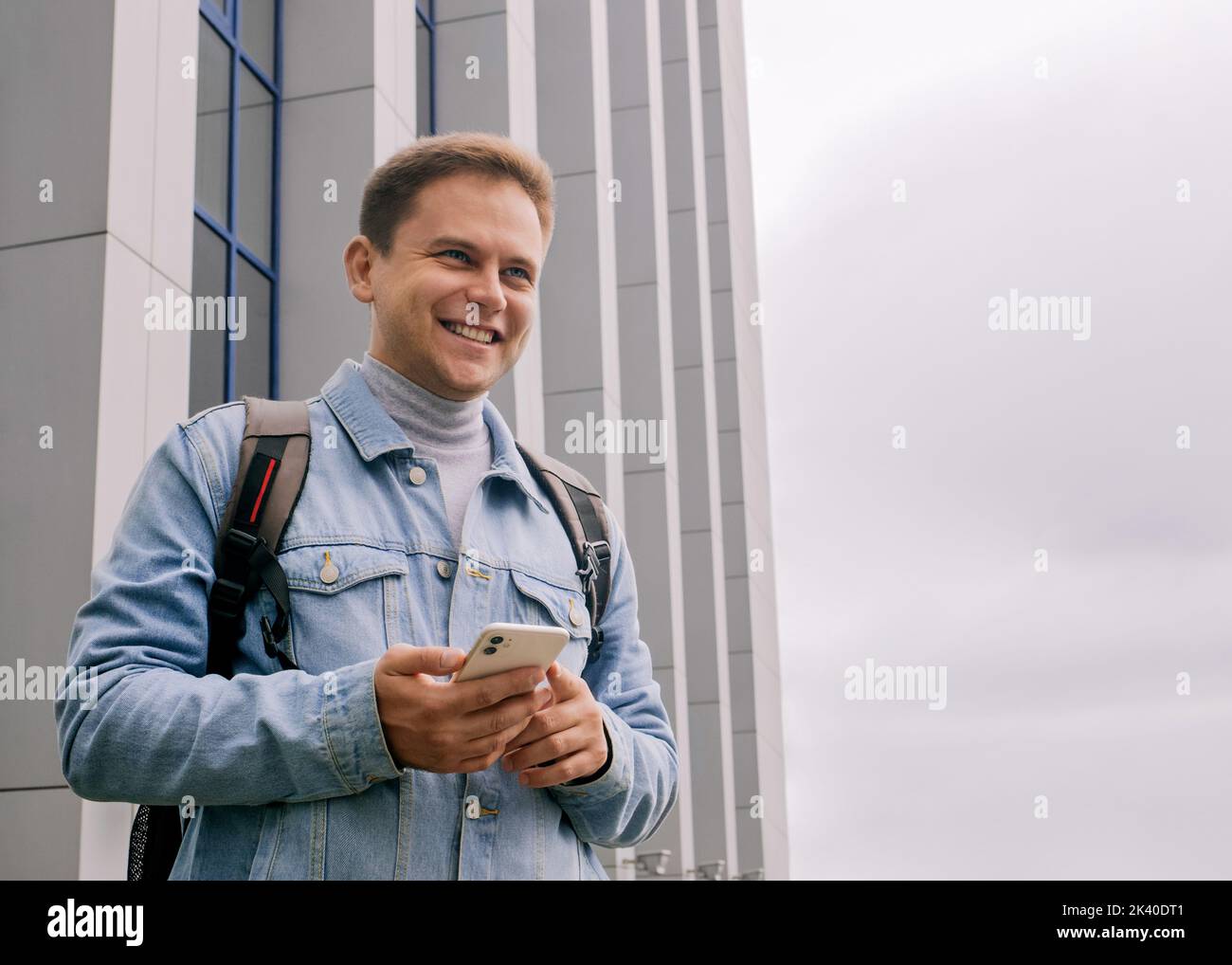 Young smiling man is holding cell phone Stock Photo