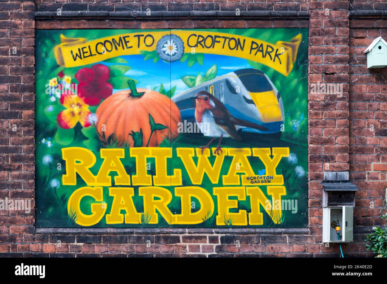 A sign reads Welcome to Crofton Park Railway Garden beside the railway station at Crofton Park in south London. Stock Photo