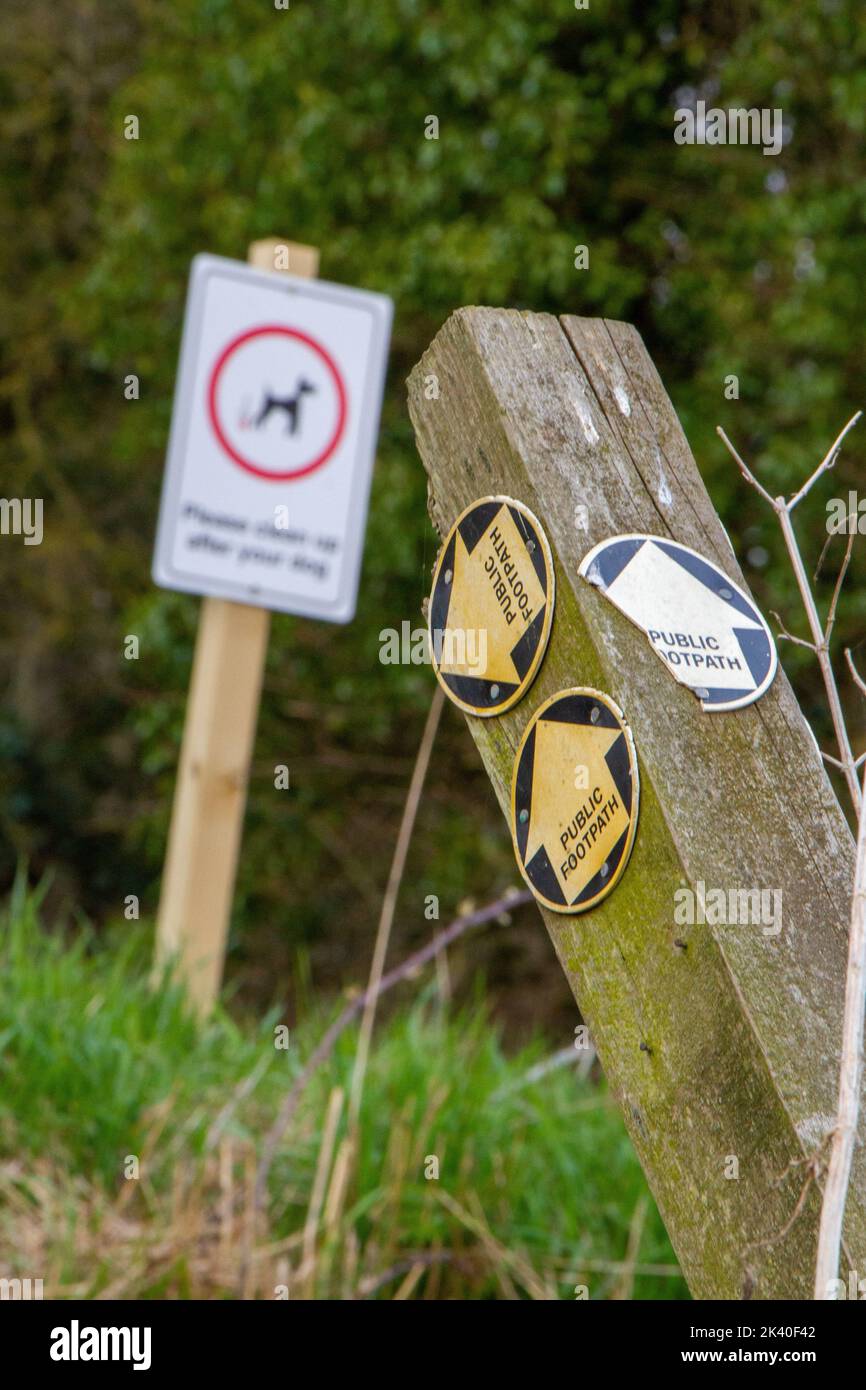 Two signs including a collapsing post with public footpath direction arrows Stock Photo