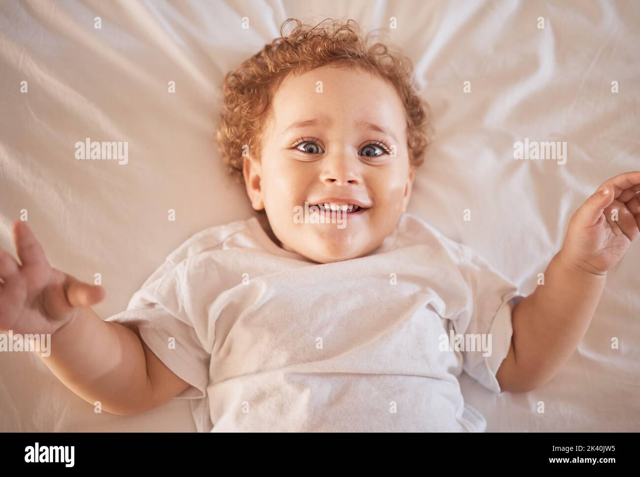 Portrait, baby boy and happy toddler children relax in bedroom, home and playful youth in Australia. Above face of cute, funny and excited young kids Stock Photo