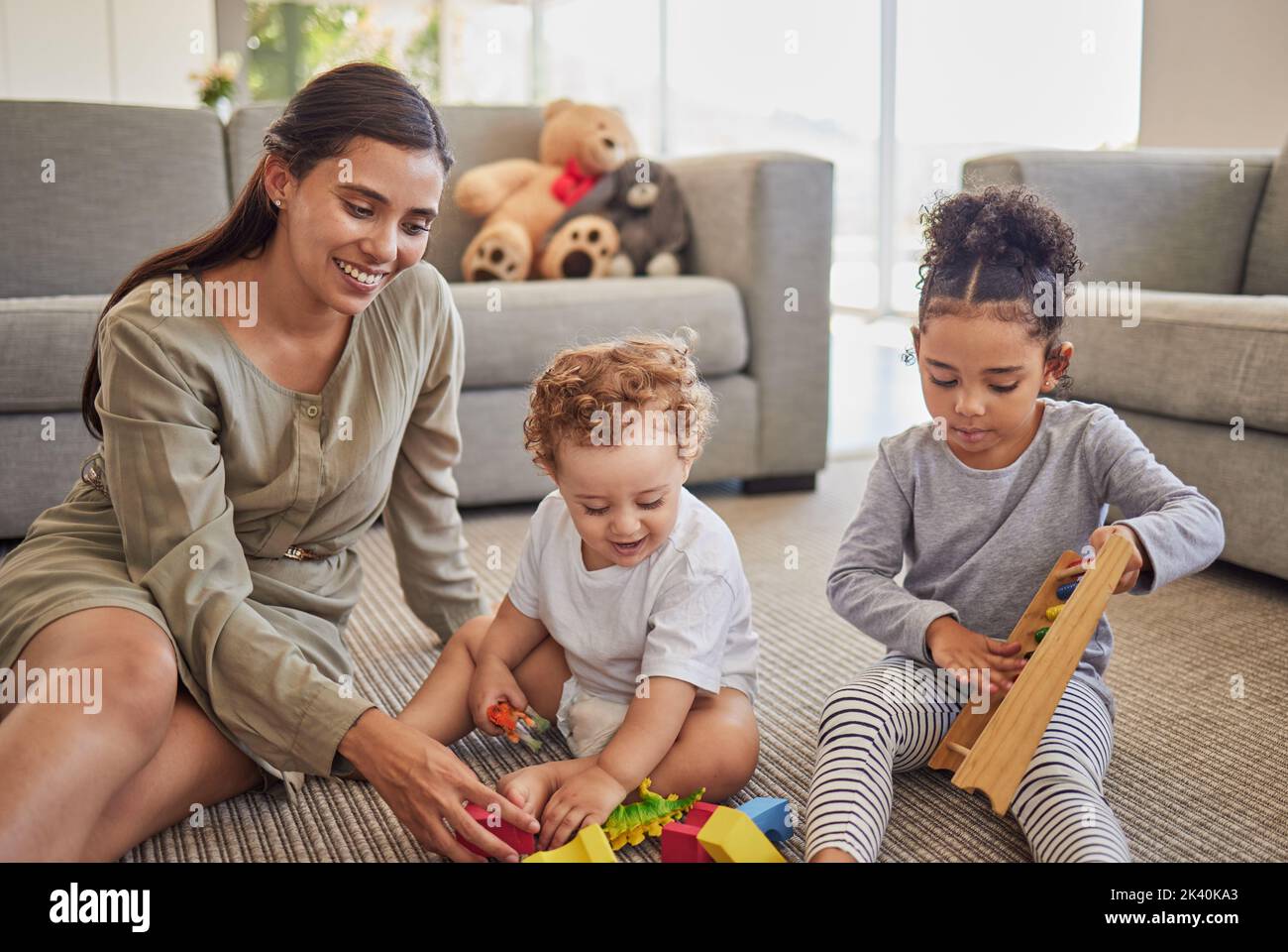 Family, mother and children playing with toys for development, education and childcare creative learning. Happy mom teaching and developing foster Stock Photo
