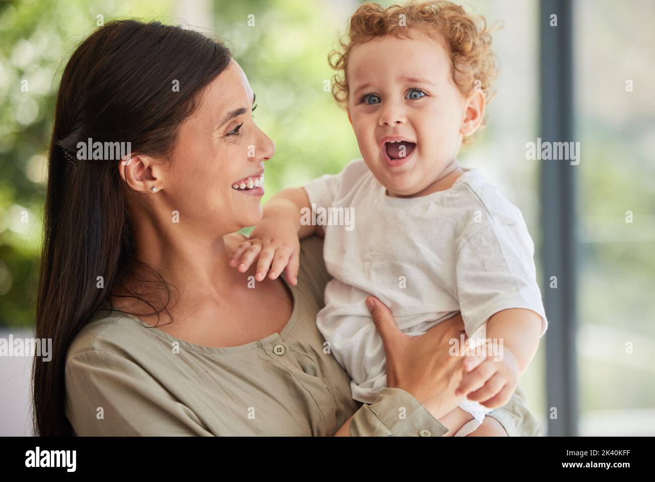 Love, happy and mother with adoption baby relaxing in interracial family home to bond together. Care, support and joy of Brazilian mom smiling while Stock Photo