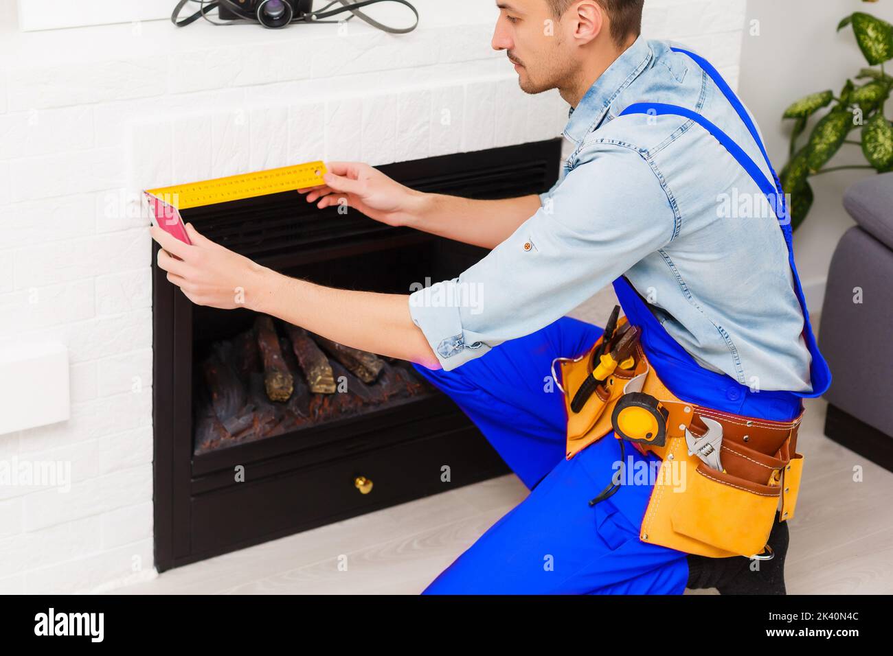 Fireplace installing in white brick wall Stock Photo Alamy