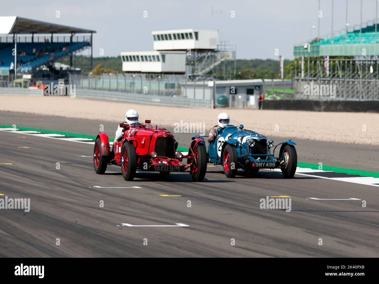 Edward Bradley in the 1935, Red, Aston Martin Ulster,  dices with Richard Little, in the 1934, Blue Riley Kestrel Sports, down the Hamilton Straight Stock Photo