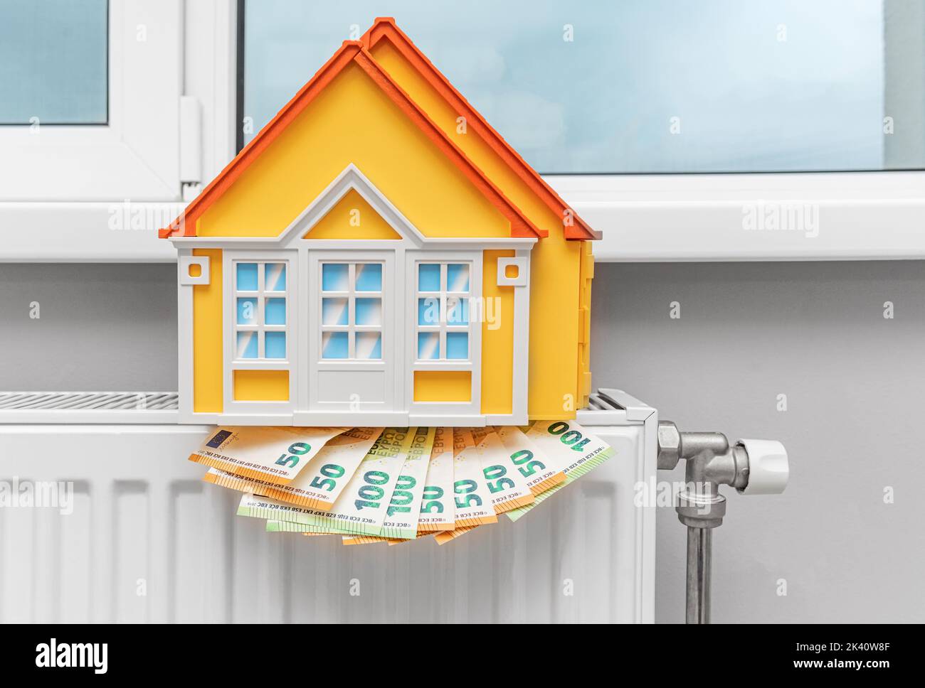 House model on a money radiator. Savings and heating season. Stock Photo