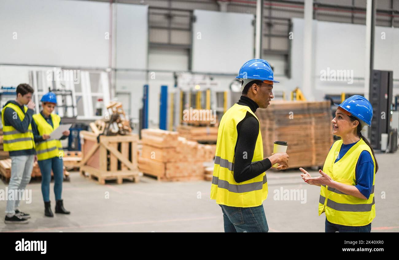 Multiracial engineers working inside robotic factory - Focus on right faces Stock Photo