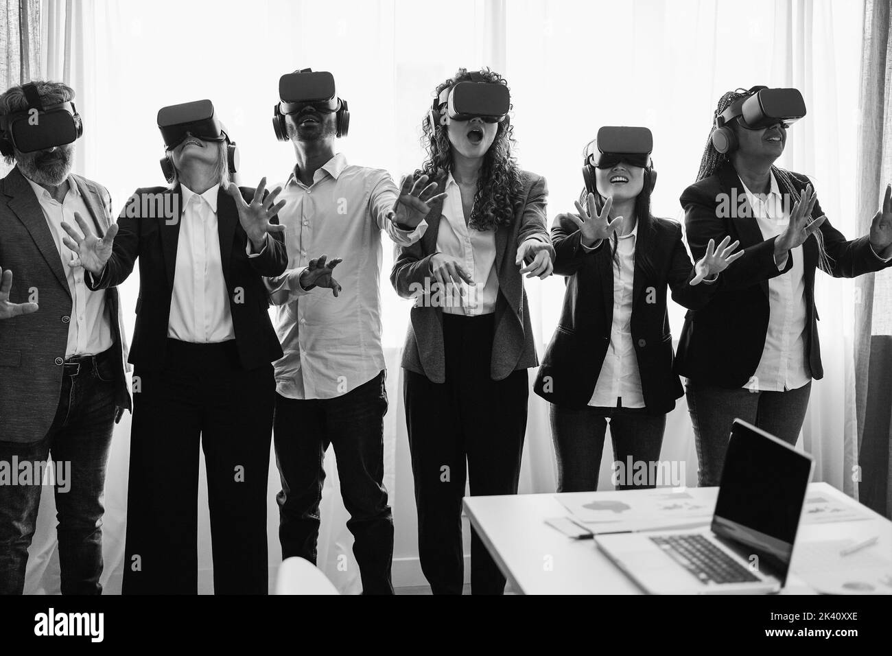 Multiracial business people wearing vr goggles inside office - Focus on center faces - Black and white editing Stock Photo