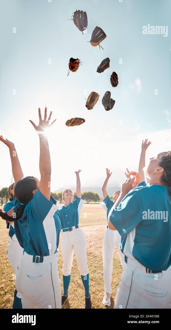 Winning team, baseball and celebration with women group throwing their gloves in victory and feeling happy after a game or match. Teamwork, softball Stock Photo