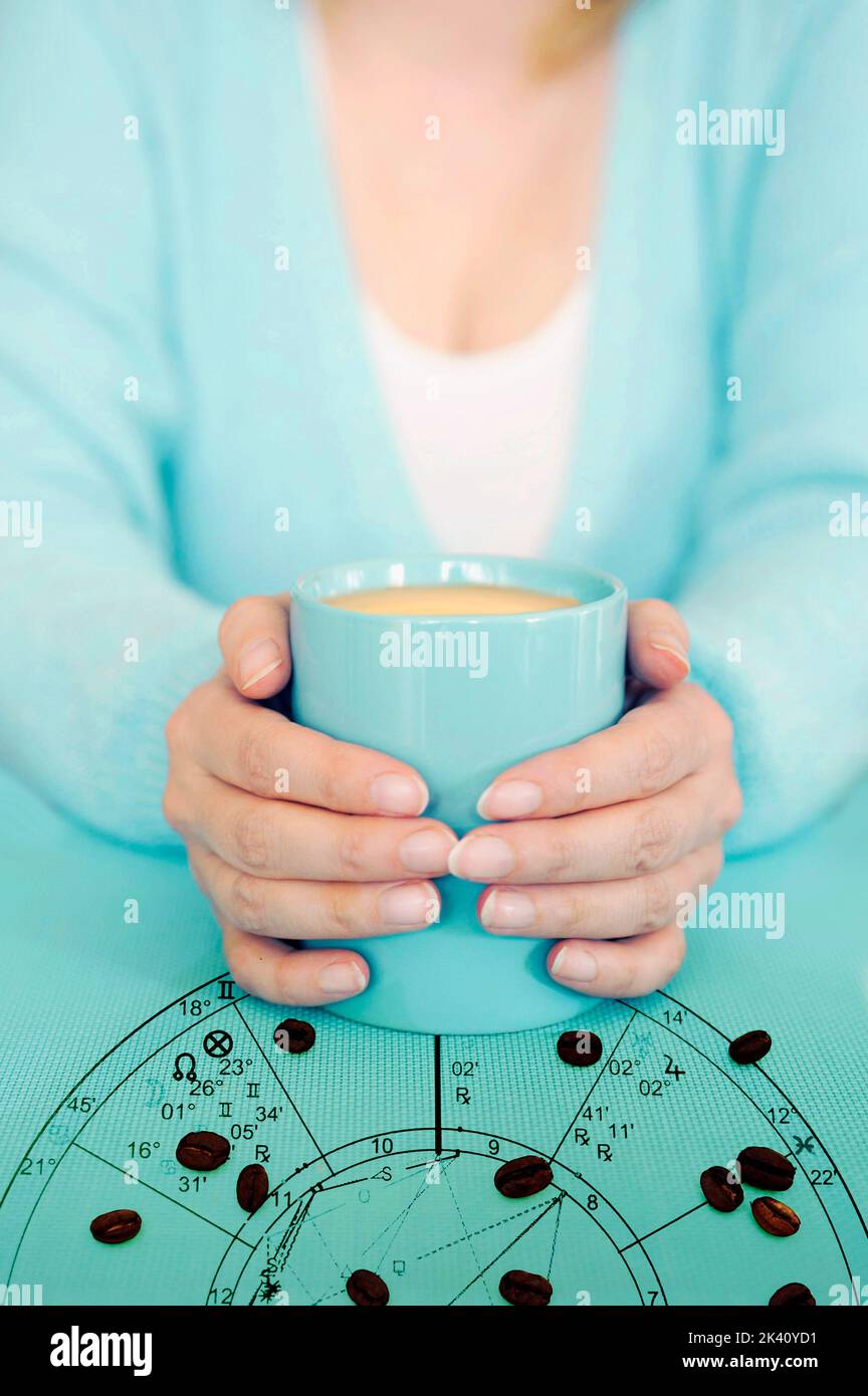 woman in aquamarine dress with aquamarine mug and horoscope with zodiac signs and coffee beans like a concept astrology and love for coffee Stock Photo