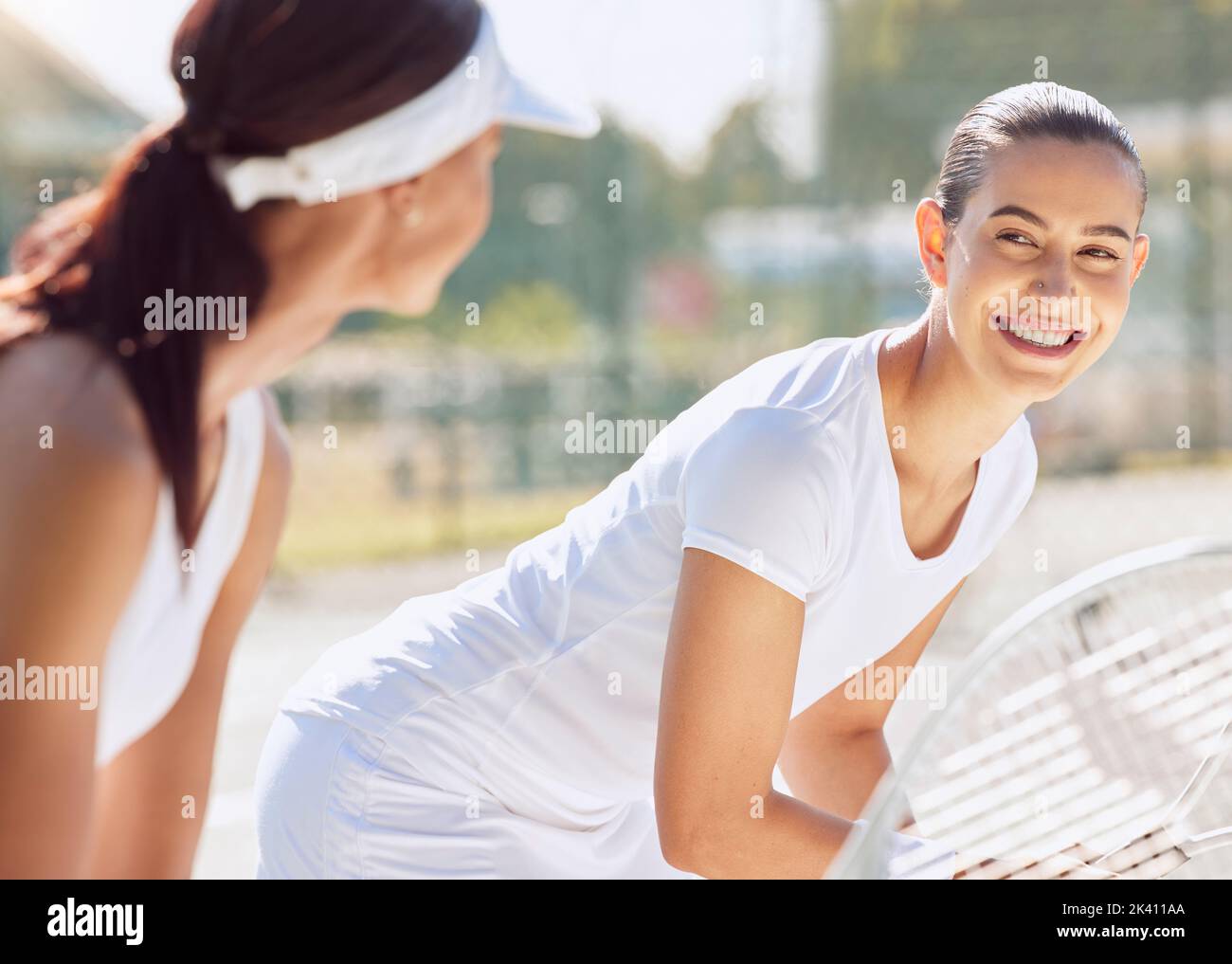 Tennis, tennis court and sports women with partner and smile on their face. Two females playing sport holding tennis rackets ready to serve, win and Stock Photo
