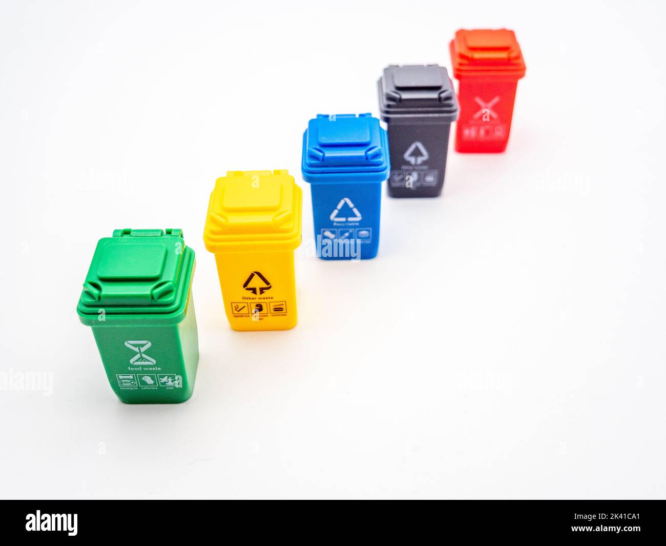 various colored recycle bins for different type of trash on white