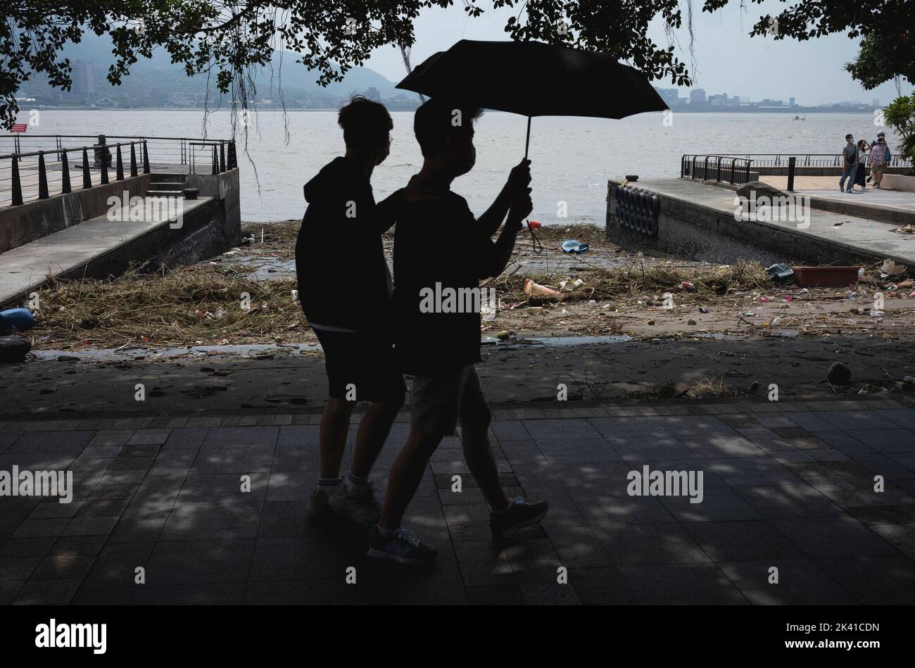 Taipei. 05th Sep, 2022. Two men with an umbrella walk along the wharf of a port where a typhoon has carried waste pollution in Tamsui, Taiwan on 05/09/2022 by Wiktor Dabkowski Credit: dpa/Alamy Live News Stock Photo