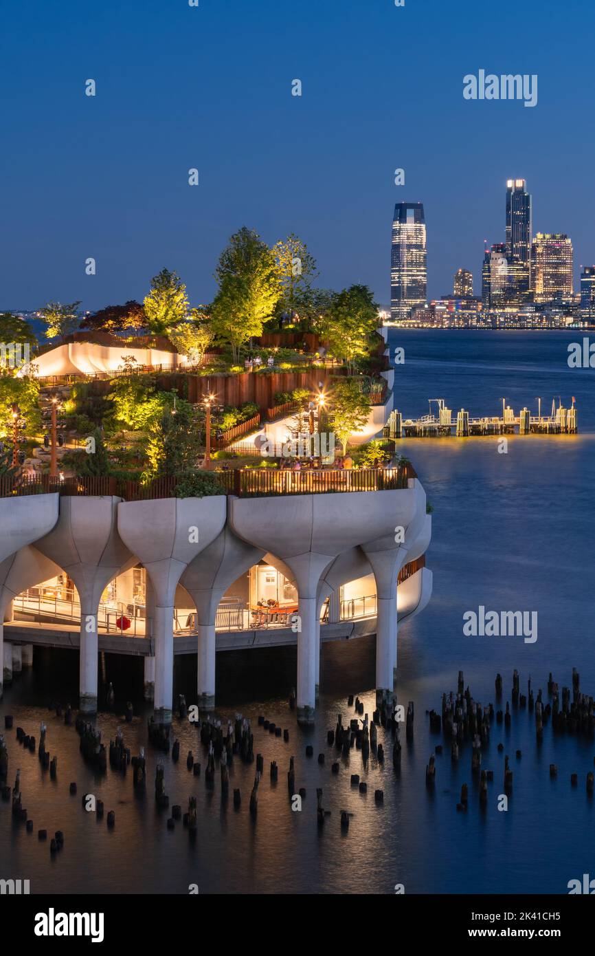 New York City, Little Island public park in evening with view of Downtown Jersey City. Elevated park at Hudson River Park (Pier 55), West Village Stock Photo
