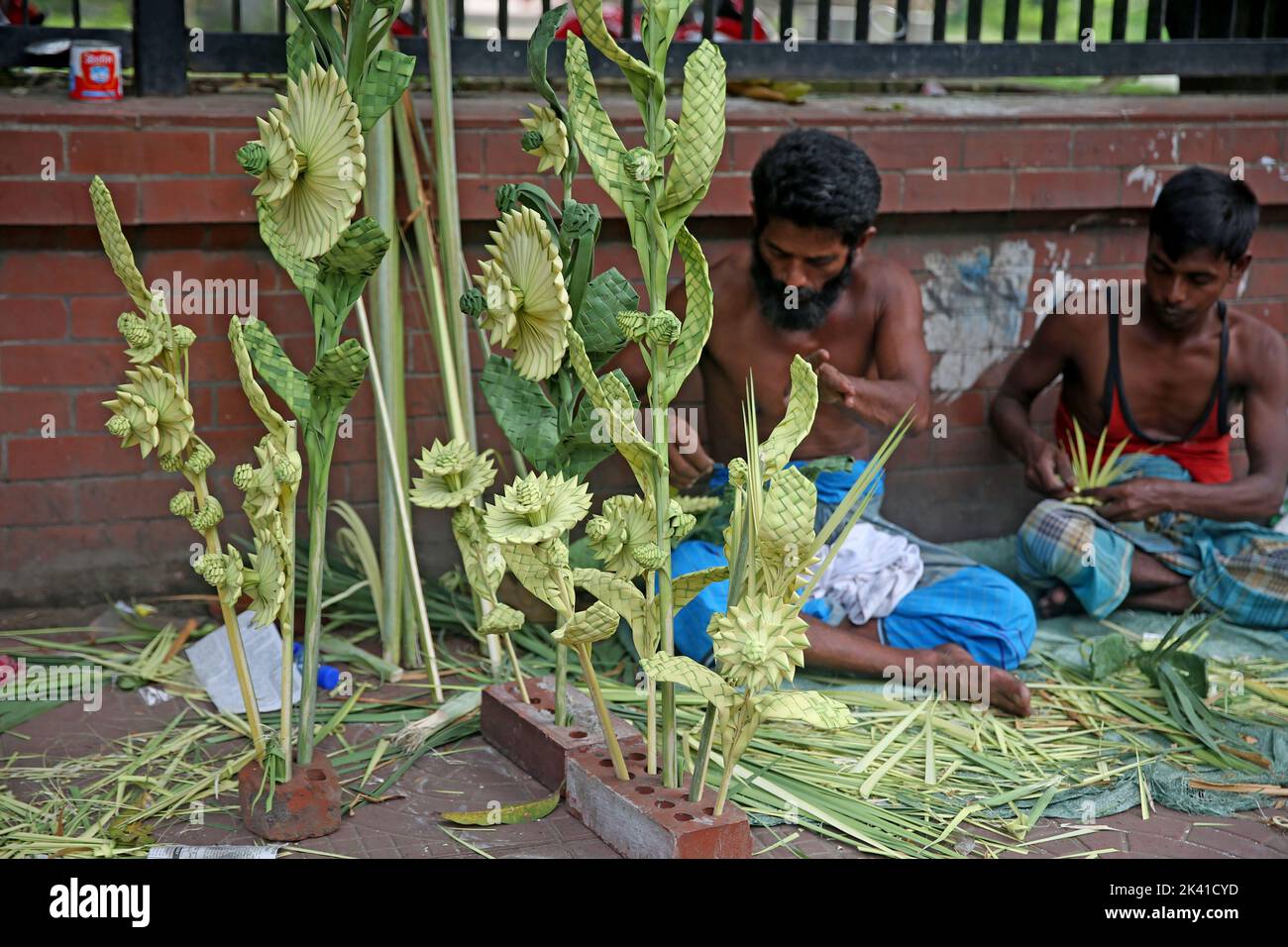 Handicraft in the form of flowers, trees and other shapes made of palm leaves. Swapan, and his helpers, Milan and Ripon, have been using this talent t Stock Photo