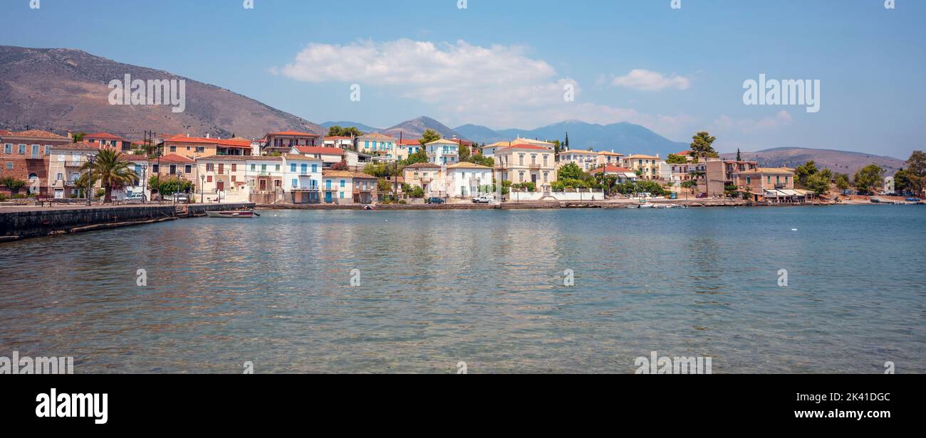 Galaxidi Greece, coastal town at Fokida. Traditional houses, cafe at seaside, moored fishing boats in colorful sea, blue sky background. Banner Stock Photo