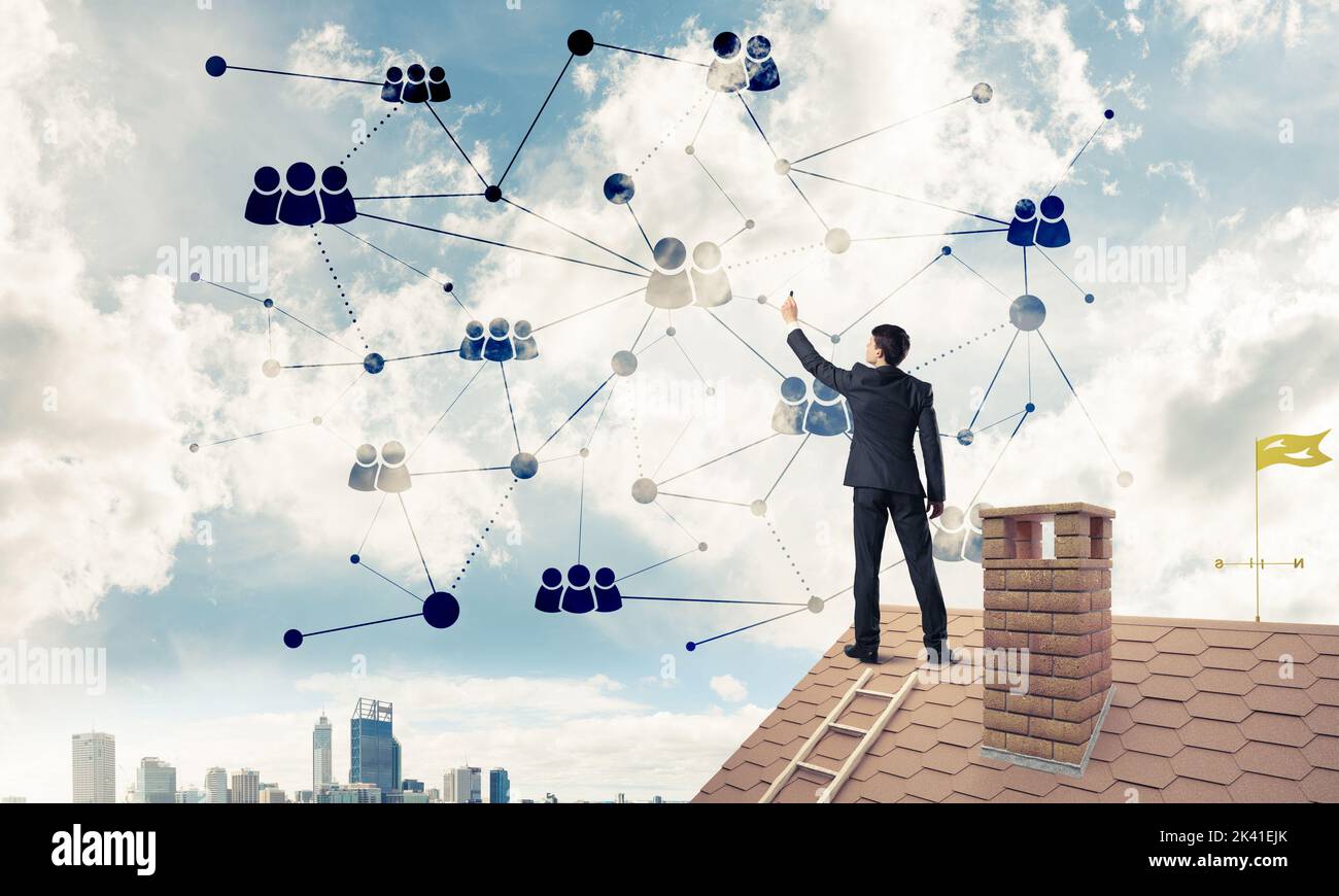 Businessman on house roof presenting networking and connection c Stock Photo
