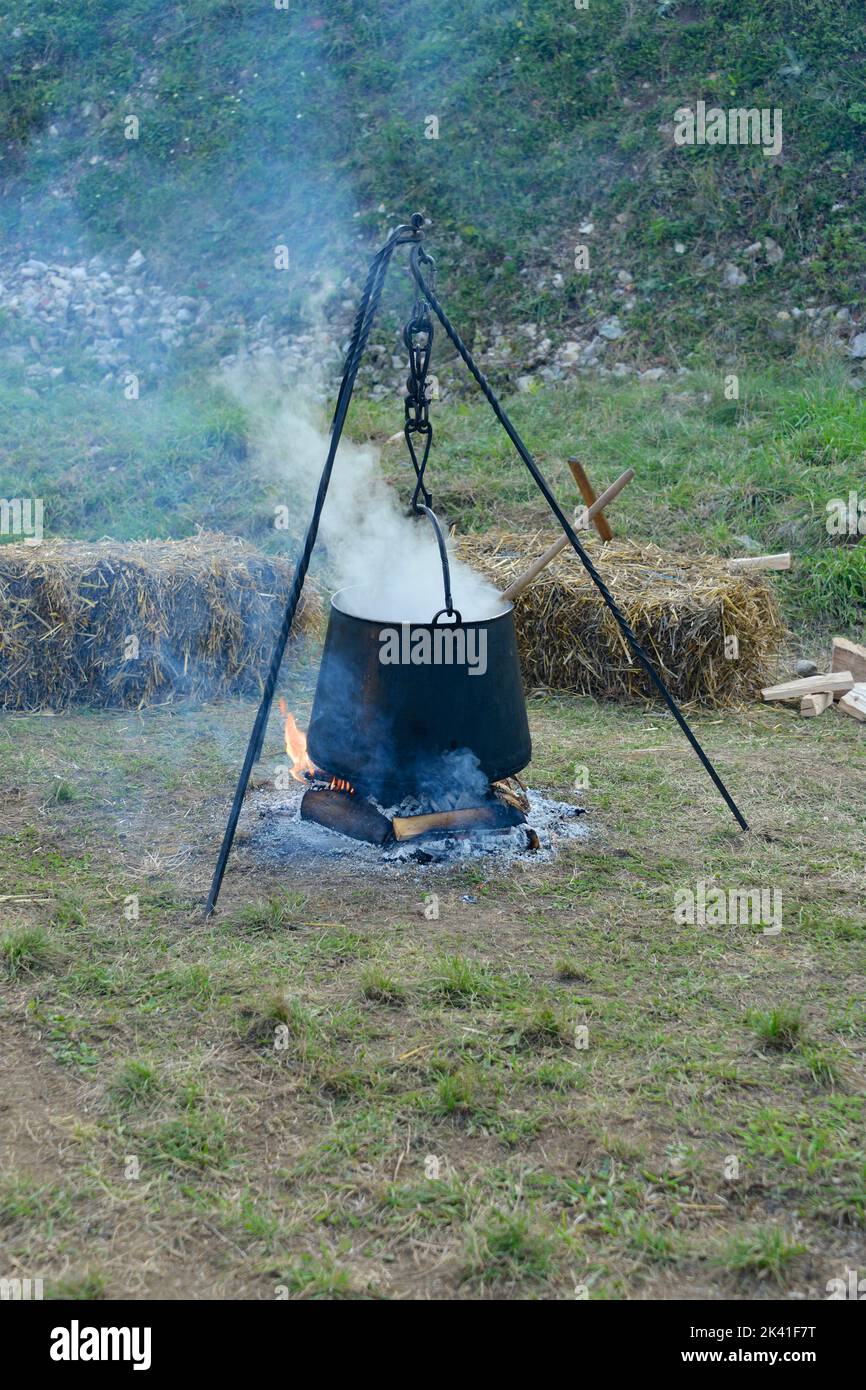 Food in a cauldron on a fire. Cooking outdoors in castiron cauldron
