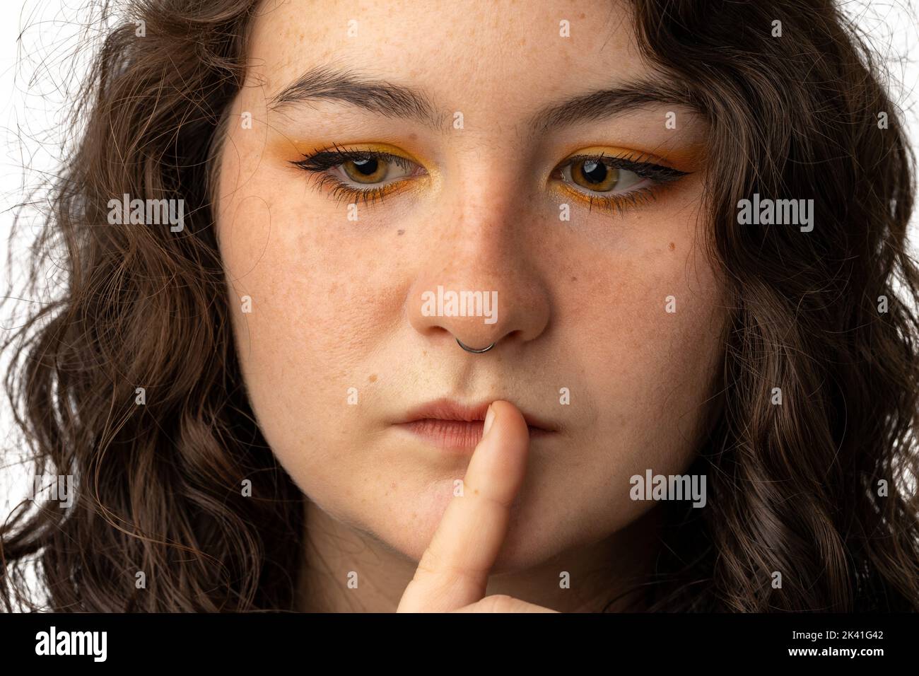 Beautiful woman with finger to mouth as if to say be quiet Stock Photo