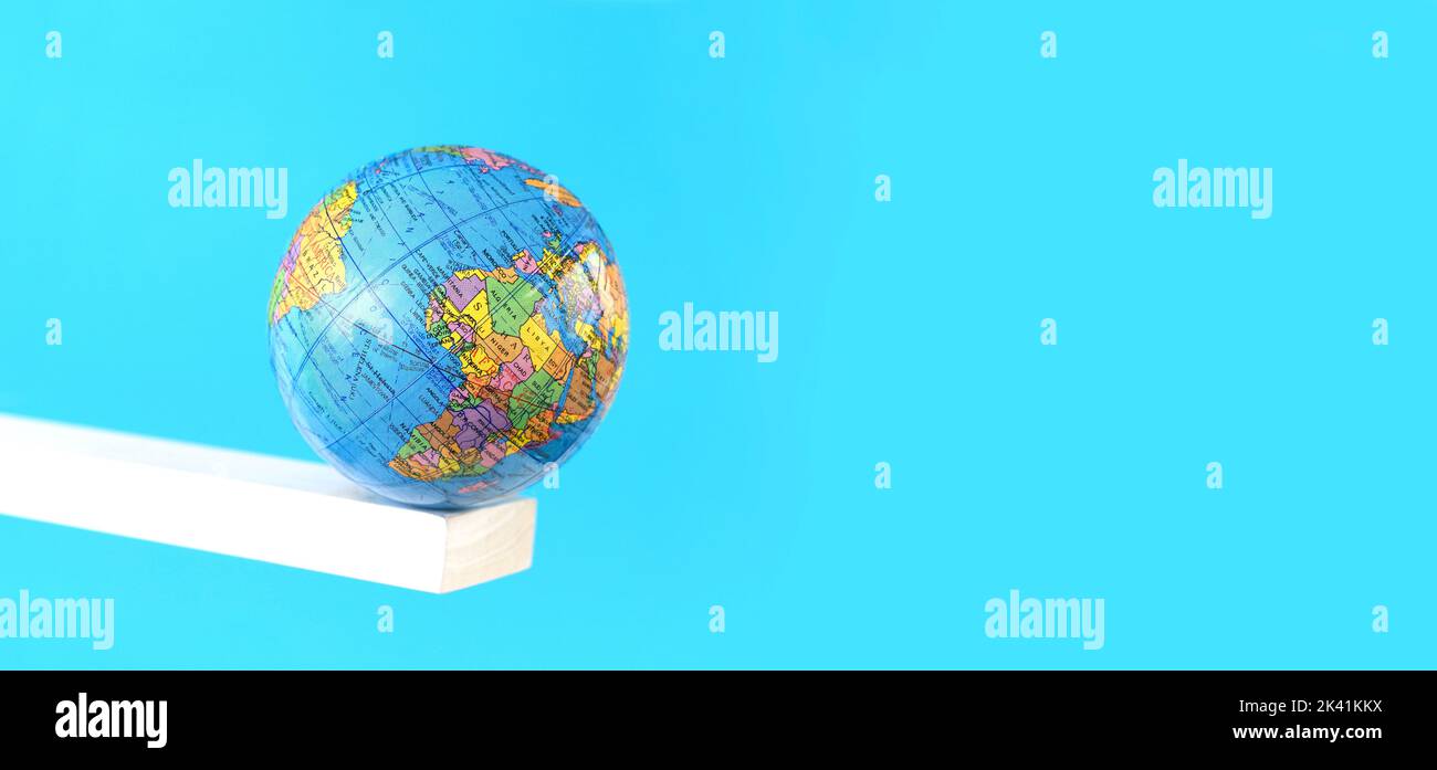 Globe precariously balanced on end of diving board Stock Photo